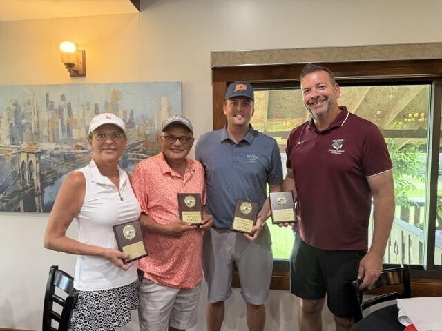 Four golf tournament winners pose together holding plaques