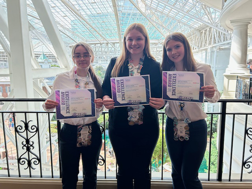 Three Health Science Careers students holding Excellence Awards at International Leadership Conference