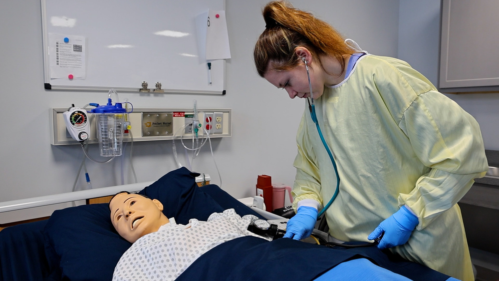 Adult nursing student checking on a mannequin