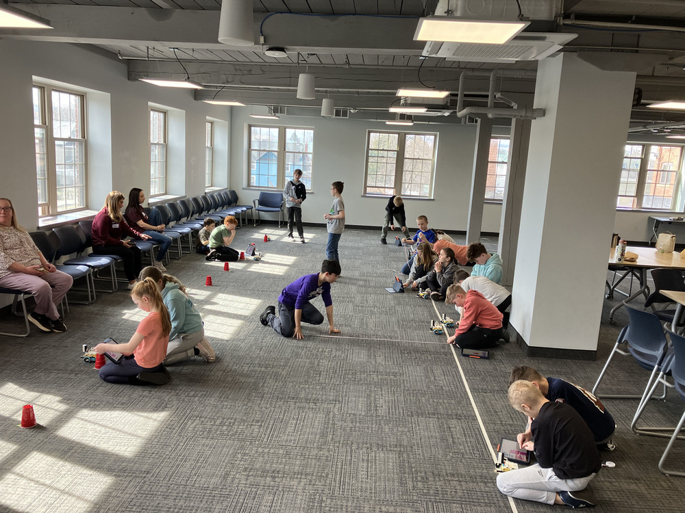 Students on floor working on robotics challenges