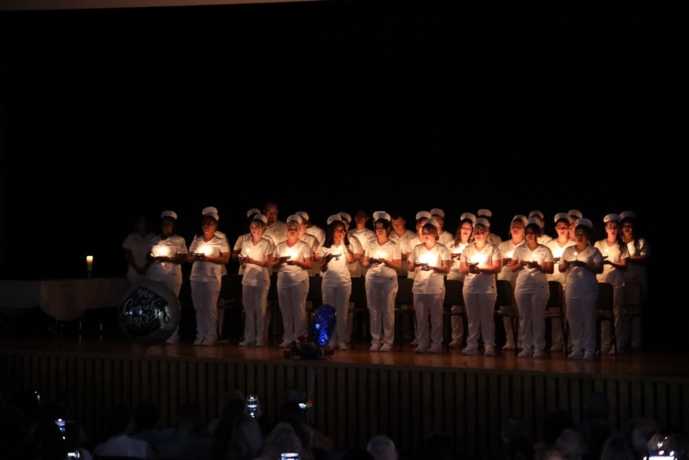 Adult LPN students taking part in candle-lighting ceremony at graduation
