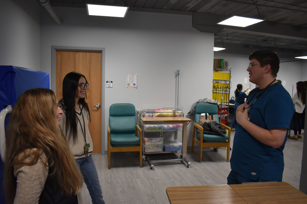 Two Open House attendees speaking to LPN student