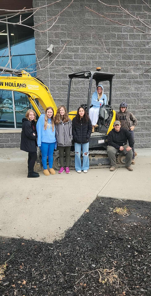 Sevent students and an excavator