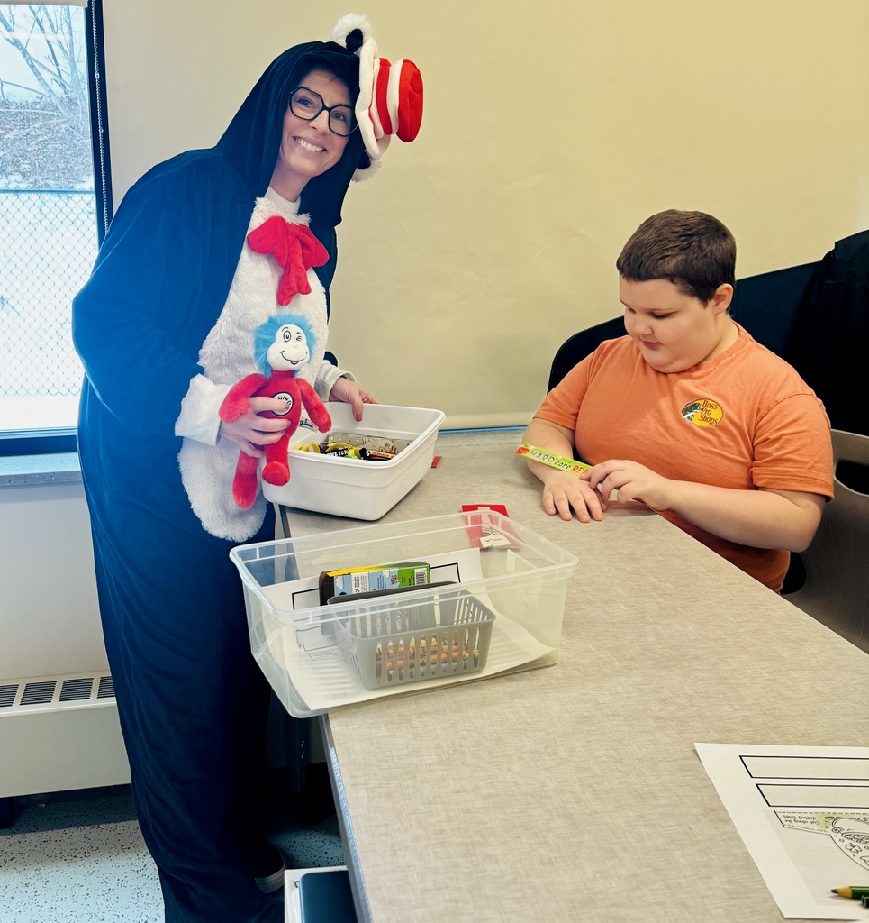 "Cat in the Hat" standing and working with a student who is sitting