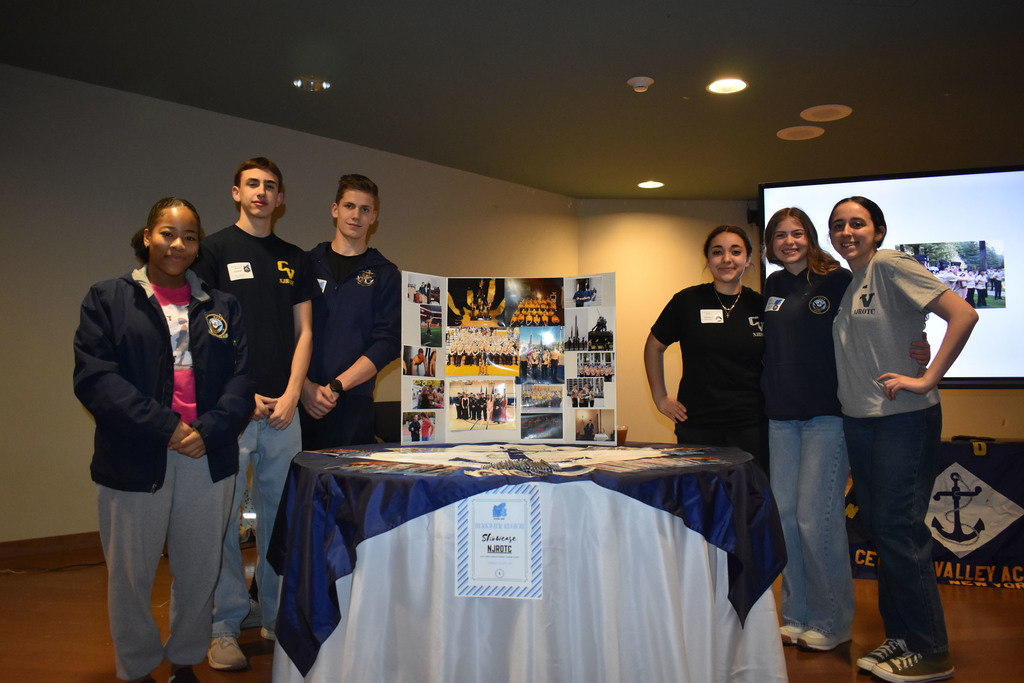 Six students around a display and table