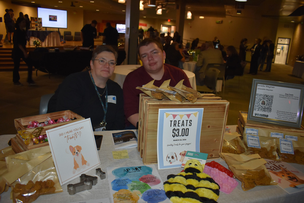 Two people at a dog treats table