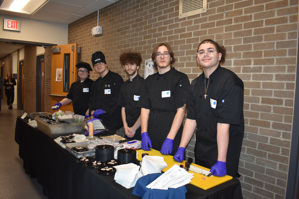 Five culinary students at a sushi station