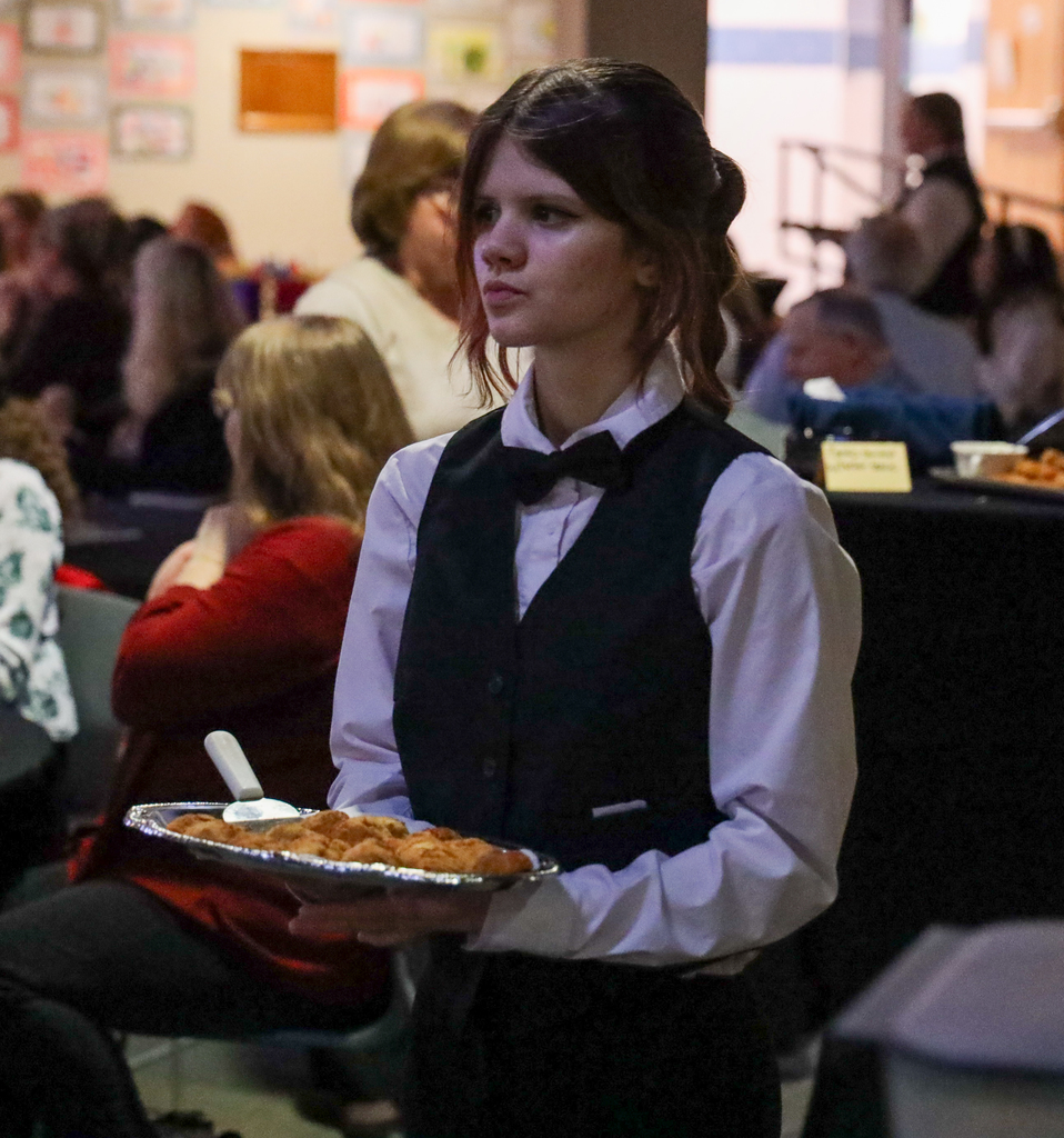 Culinary student serving food