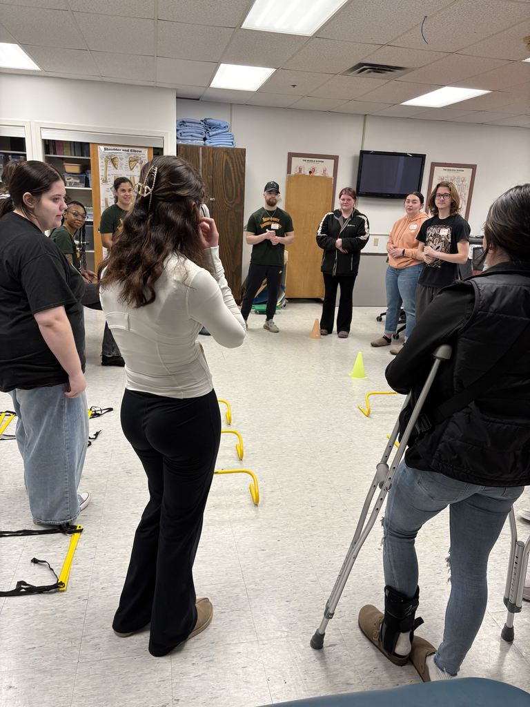 People standing in a circle in a classroom