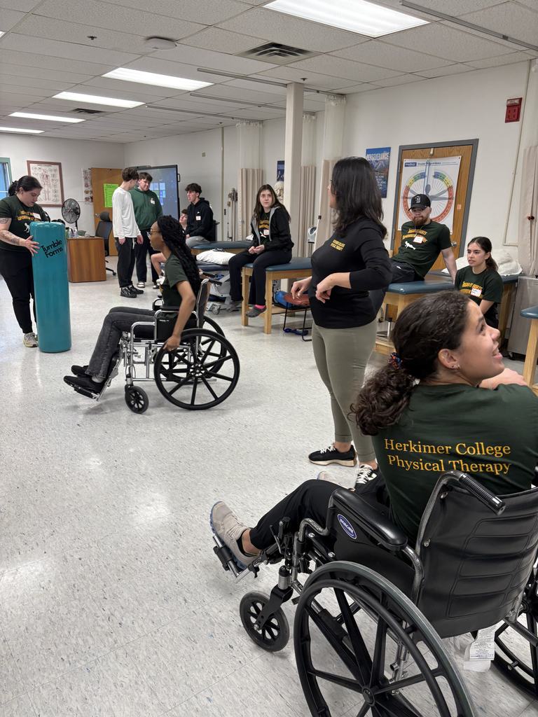 People standing, sitting and trying out wheelchairs