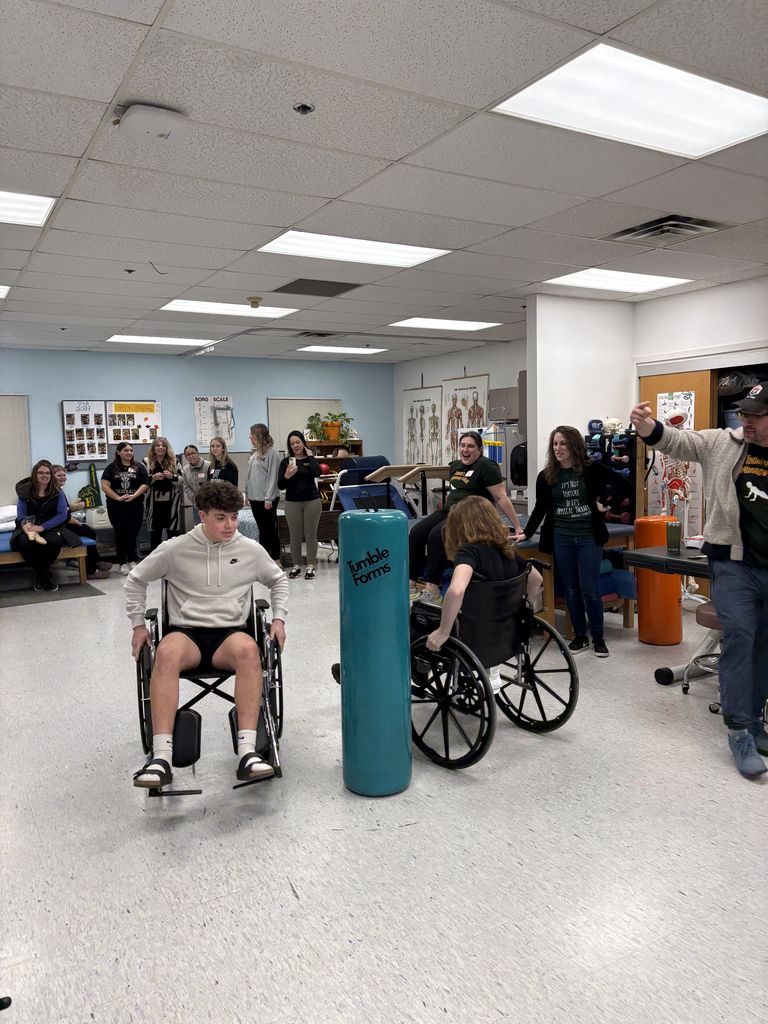People standing, sitting and trying out wheelchairs