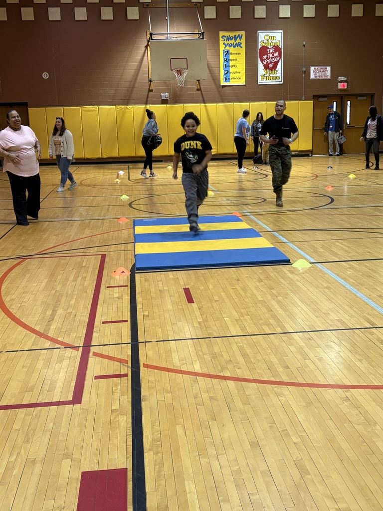 Marine Corps Staff Sgt. Paredes and a student running in the gym with other students and staff nearby