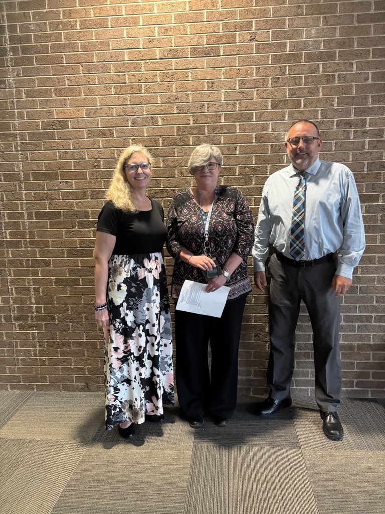 Three people posing by lobby wall