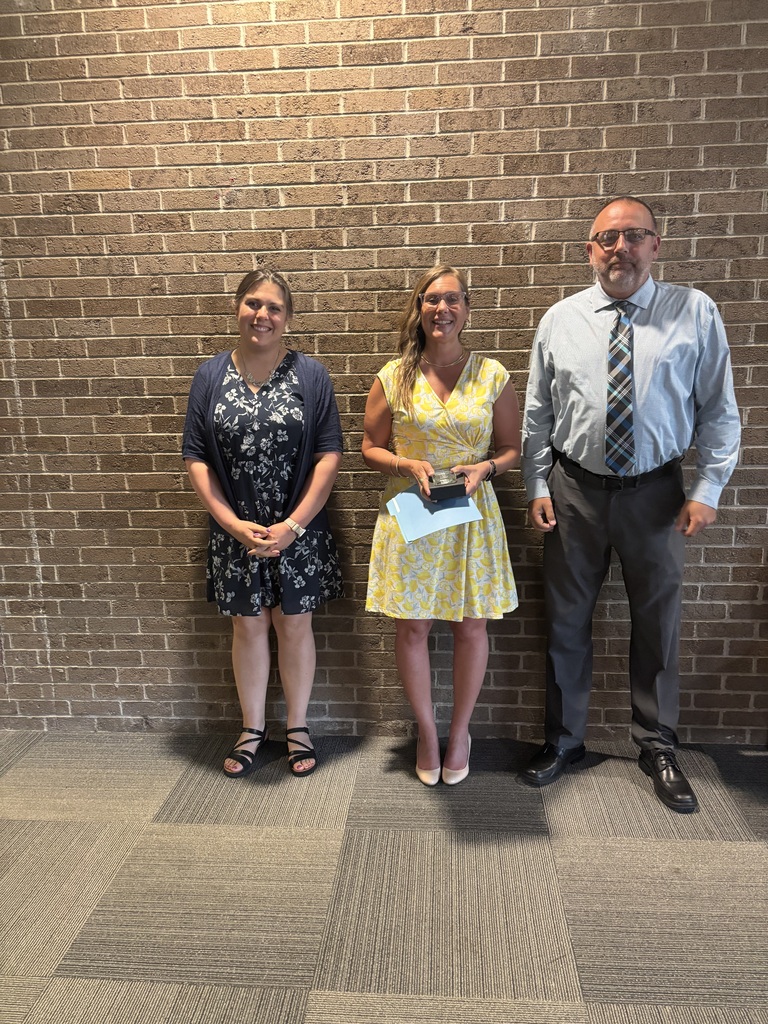 Three people posing by lobby wall