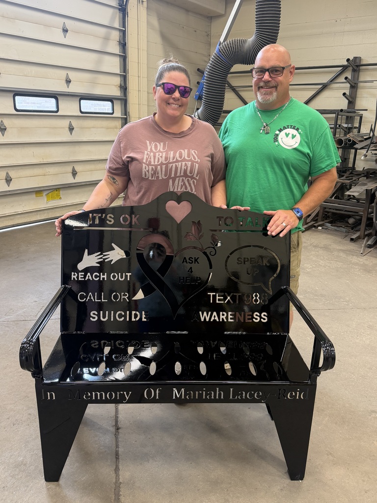 Brandie Reid and Rick Reid with a bench that Welding students made