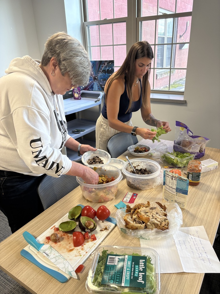 Two people leaning over a table covered with food