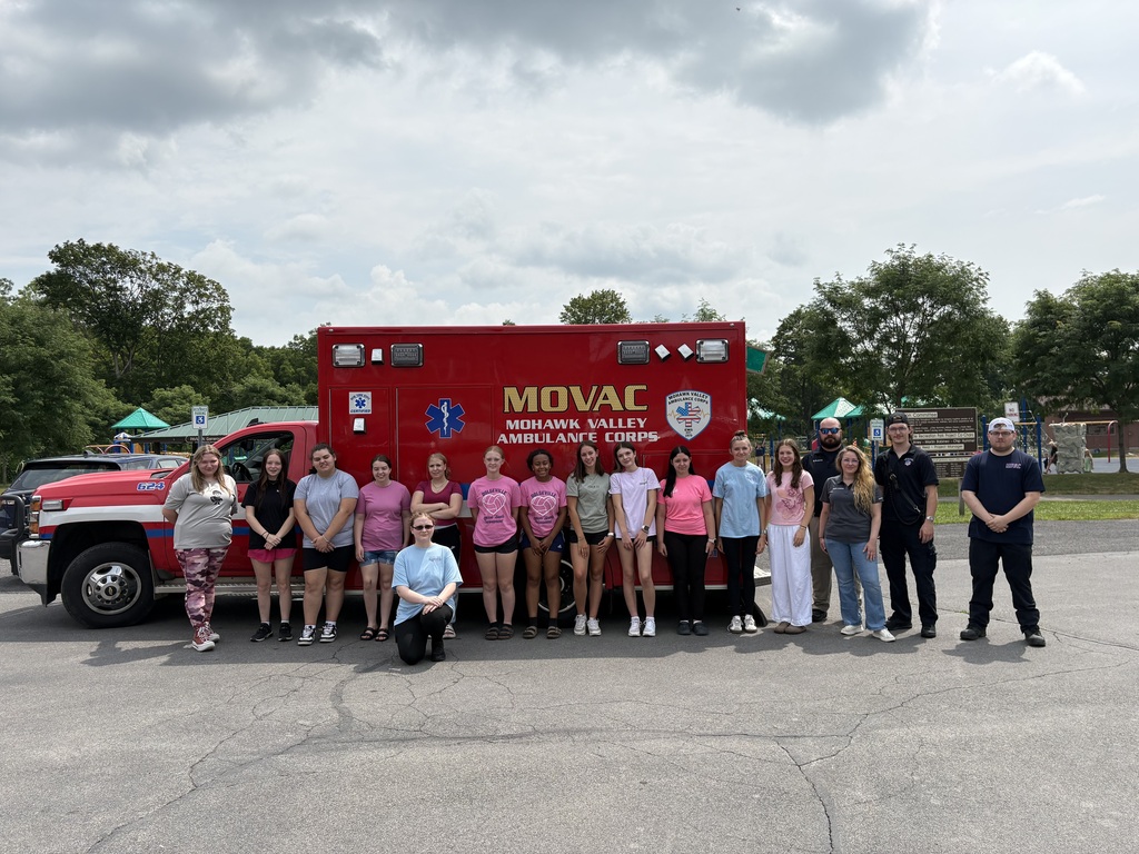Students and others pose by ambulance