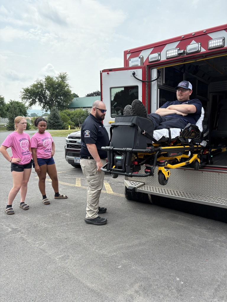 Students watch ambulance demonstration with two workers