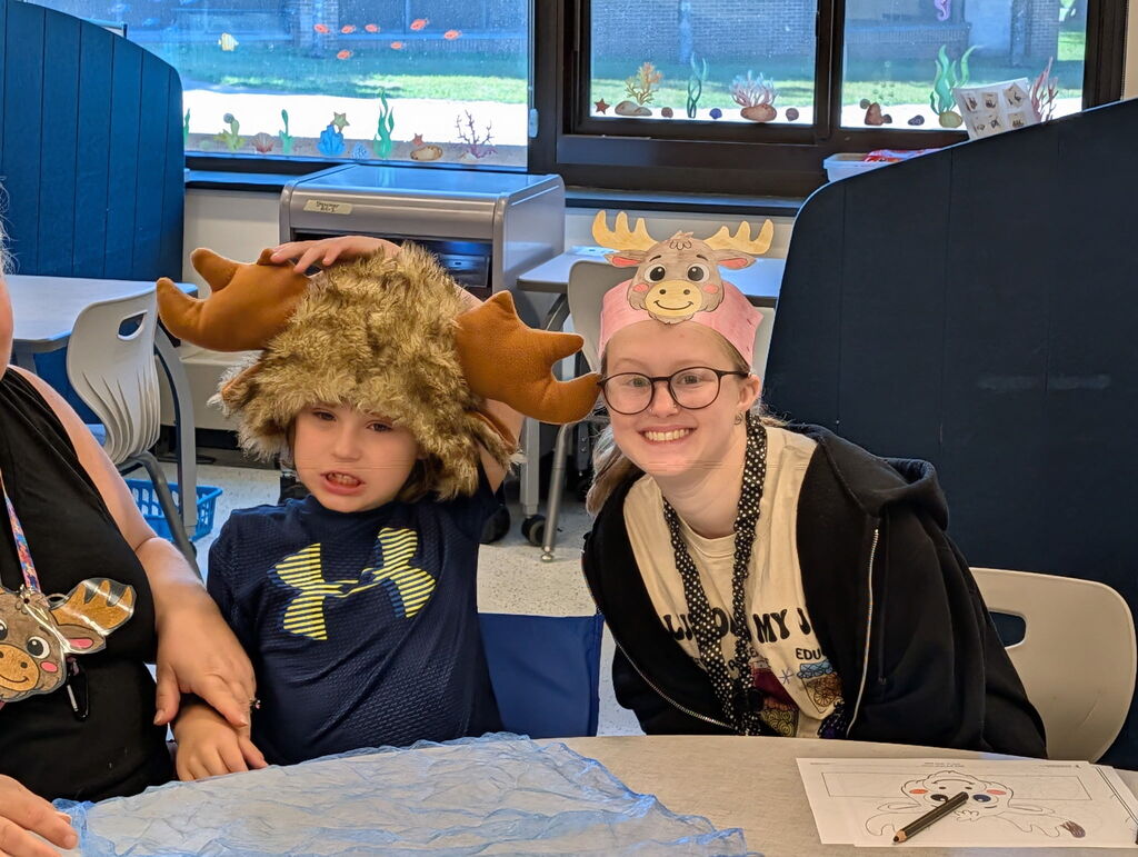 Two people at a table wearing animal headgear