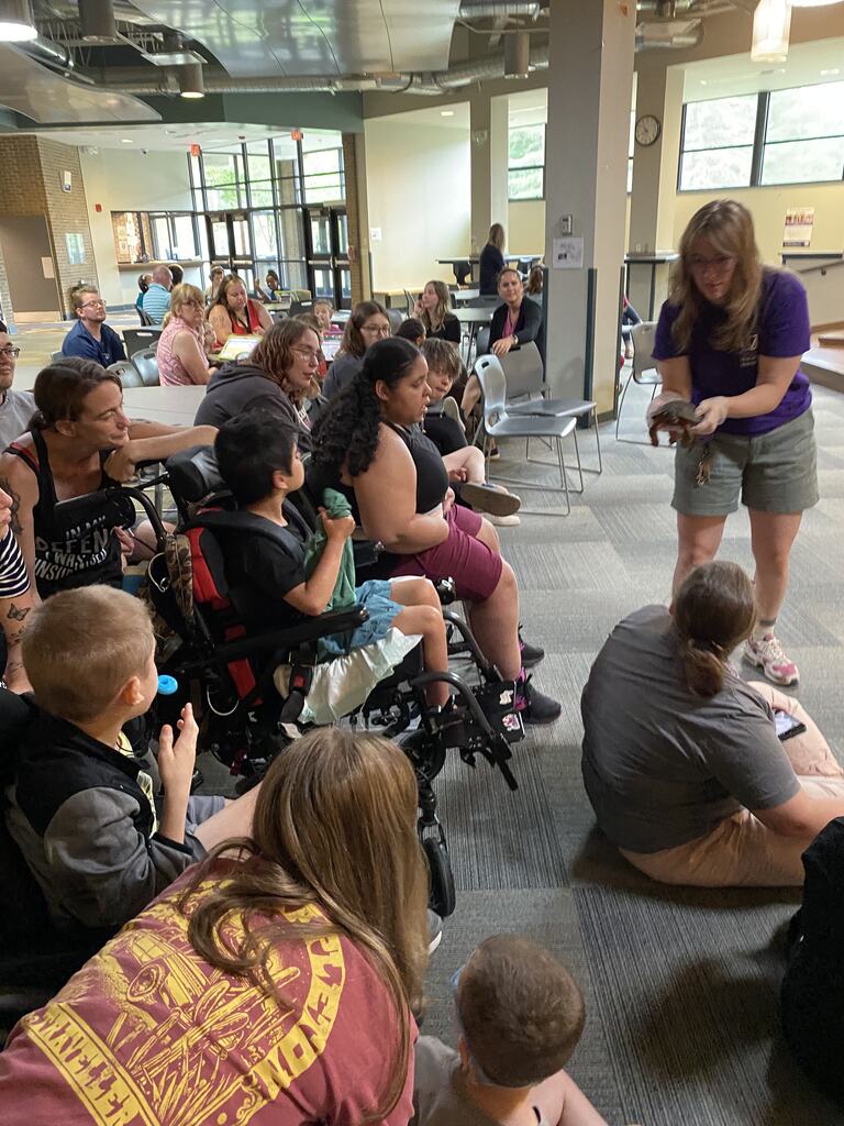 Utica ZooMobile visit to WEB Complex with exhibitor showing a turtle to students and staff