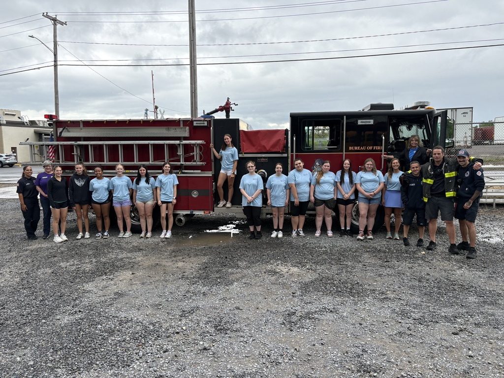 Students, firefighters and staff by a fire truck