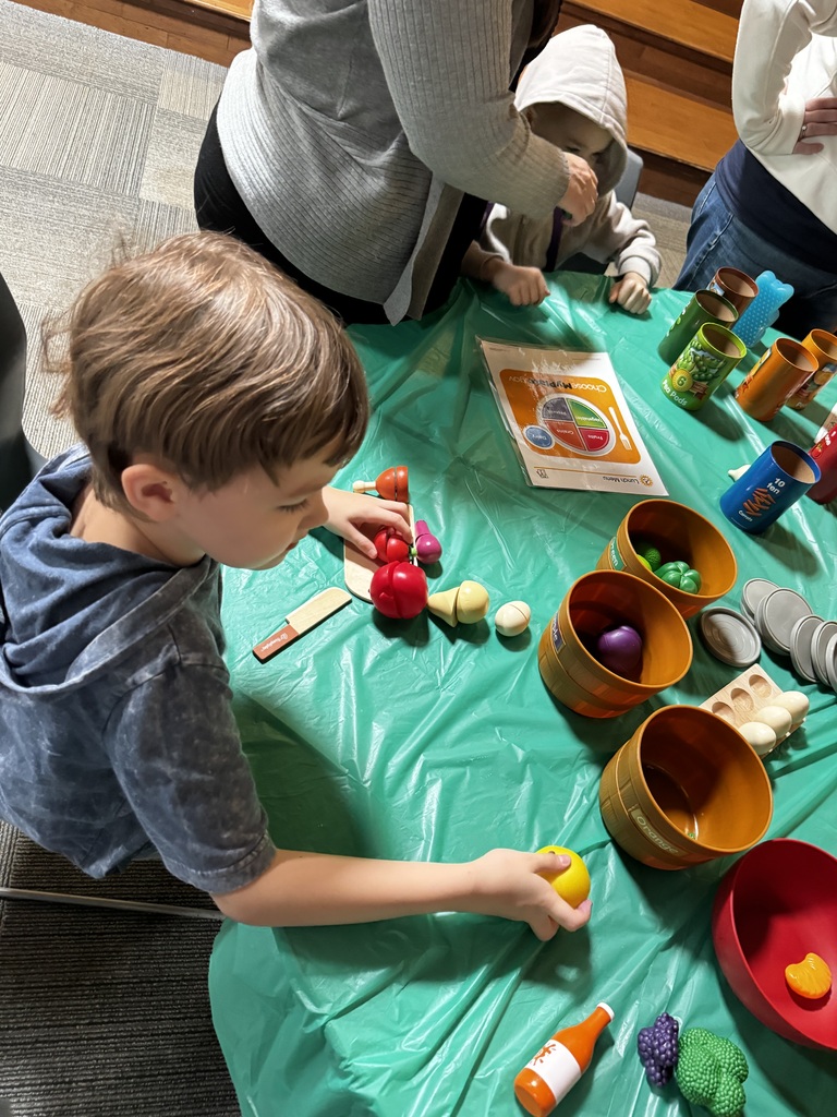 Student using toy food at a table