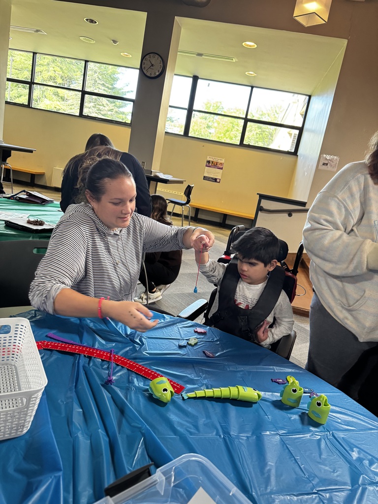 Person helping a student at a table with an activity