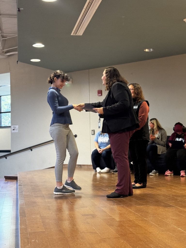 Student Council member shaking hands on stage as being recognized