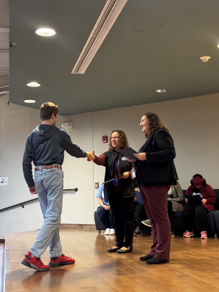 Student Council member shaking hands on stage as being recognized