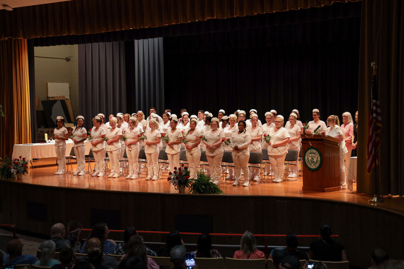 Adult LPN graduates standing on stage
