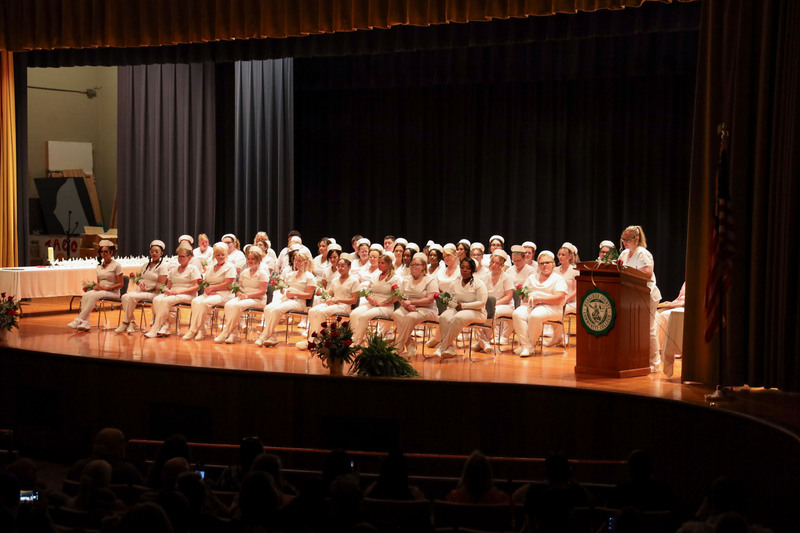 Adult LPN graduates sitting on stage