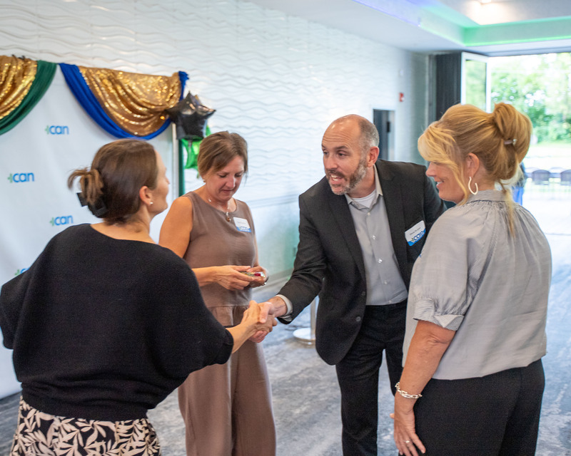 ICAN president presents award to three Herkimer BOCES staff and shakes hands with one of them