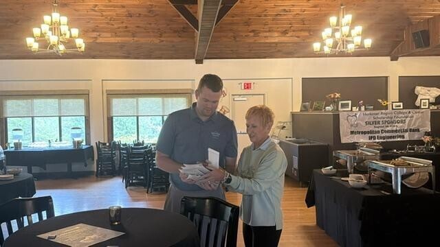 People receiving awards inside after golf tournament