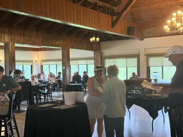 People receiving awards inside after golf tournament