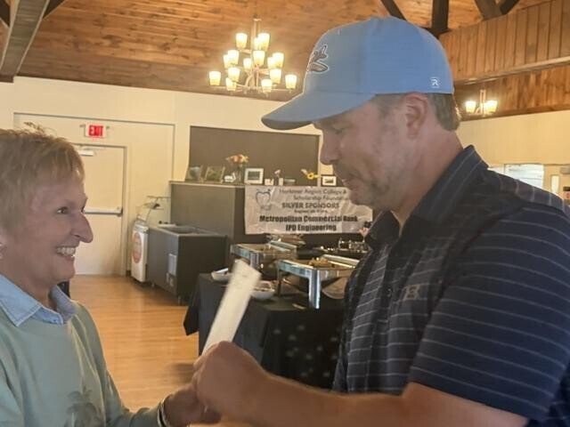 People receiving awards inside after golf tournament