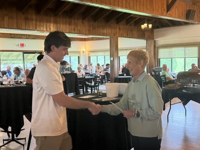 People receiving awards inside after golf tournament