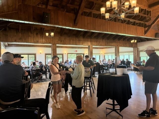 People receiving awards inside after golf tournament