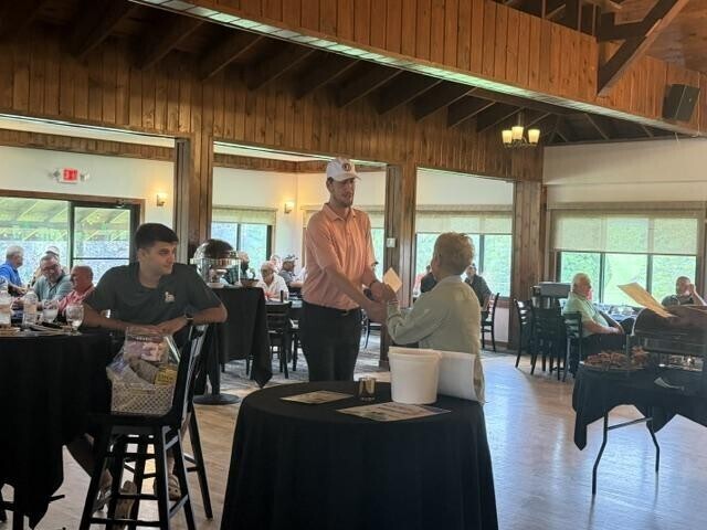 People receiving awards inside after golf tournament