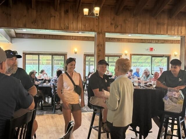 People receiving awards inside after golf tournament