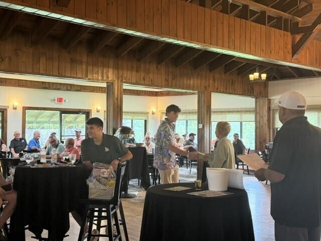 People receiving awards inside after golf tournament