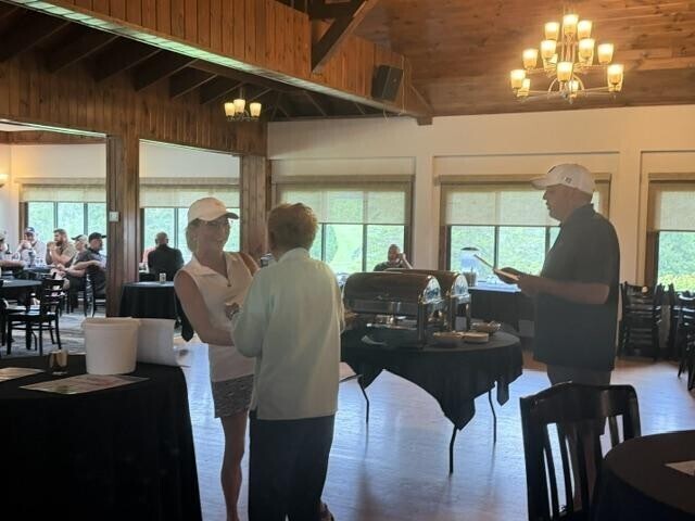 People receiving awards inside after golf tournament