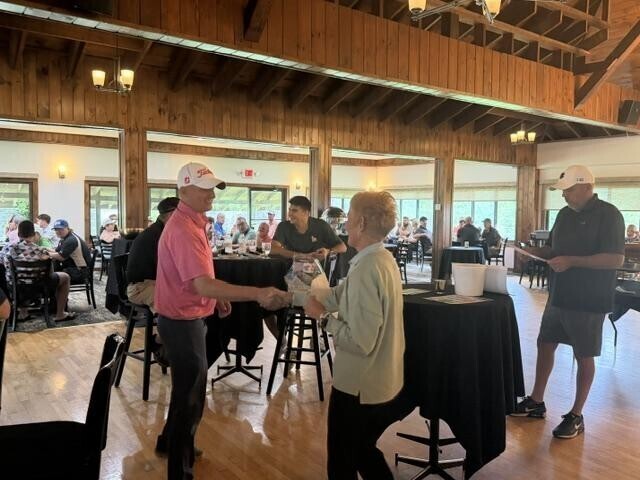 People receiving awards inside after golf tournament
