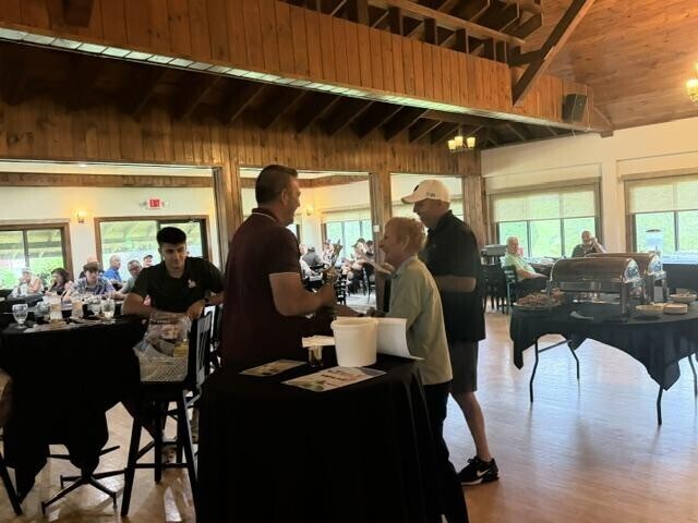 People receiving awards inside after golf tournament