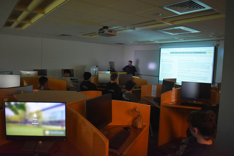 VP-TECH students at desks listening to Herkimer College library director in library classroom