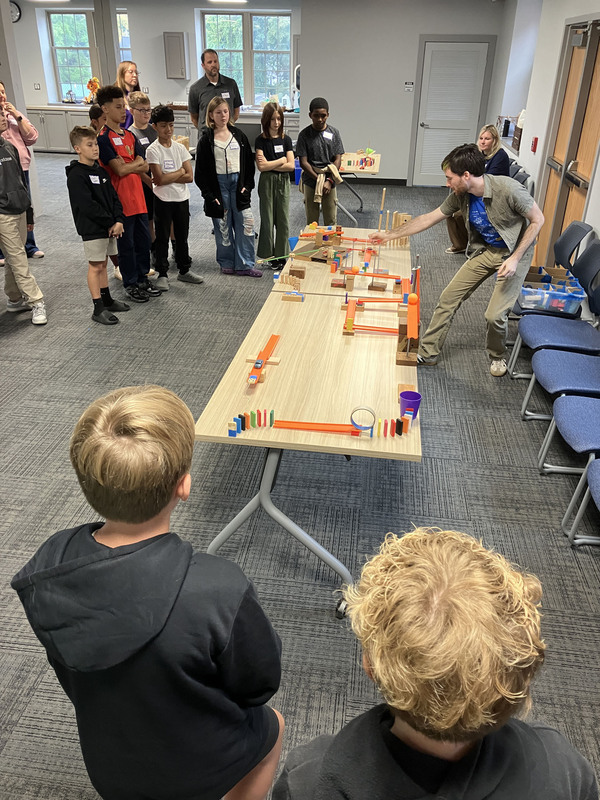 Sixth graders look on as Merlin Katz from Playful Engineers presents to them