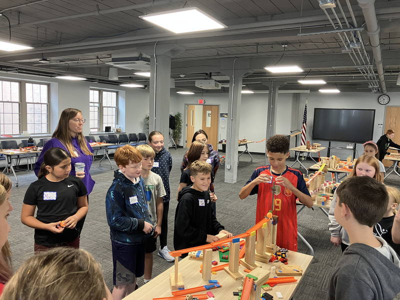 Sixth graders standing and working on engineering projects