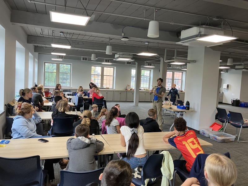 Sixth graders look on as Merlin Katz from Playful Engineers presents to them