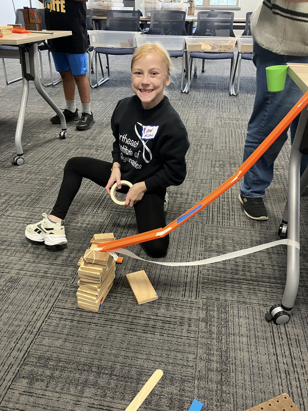 Student posing with engineering projects