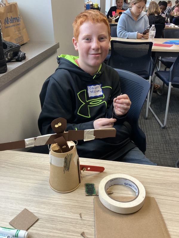Student posing with engineering projects