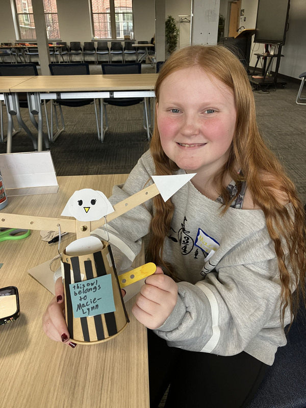 Student posing with engineering project